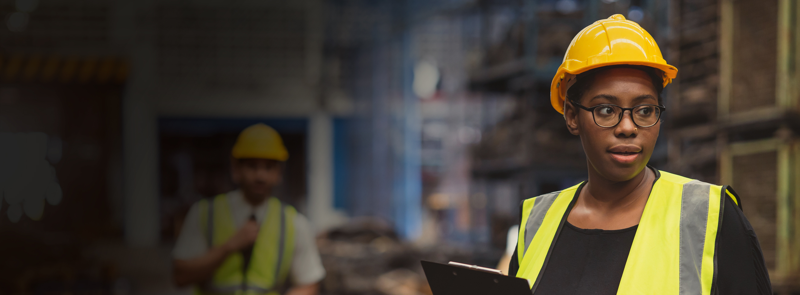 A construction worker on site holding a tablet monitoring the workforce.